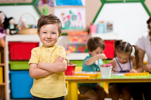 Child crossing arms and smiling at camera